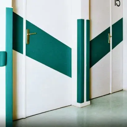 Dekorativna zaštita za vrata u hodniku – zeleni kosi dekorativni odbojnici na belim vratima
