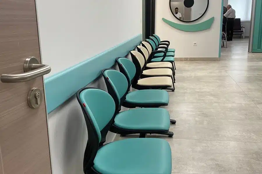 Tirkizni Pvc odbojnik zidni VOX postavljen u visini naslona stolica u čekaonici ambulante.