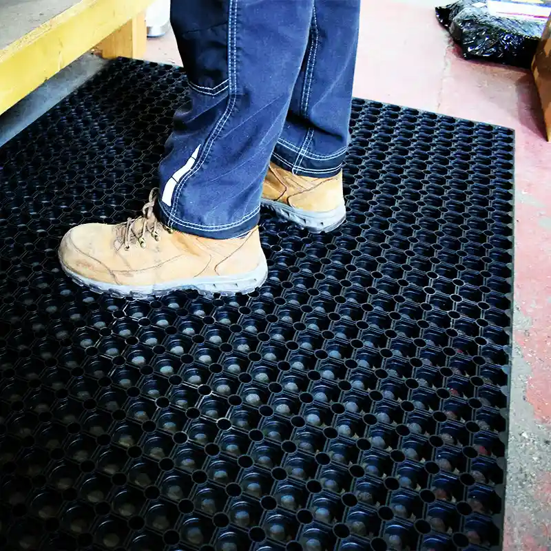 Industrijski otirači QUARTA gde radnik u radnim čizmama na stoji na podlozi – zaštita od klizanja u pogonu