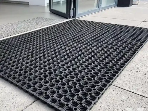 Spoljni otirači Forest postavljeni ispred staklenog ulaza u modernu zgradu.